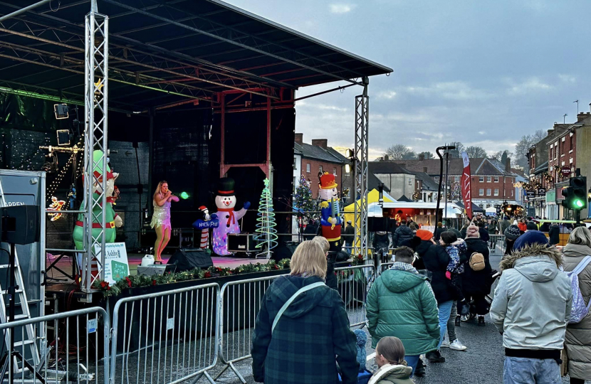 View of the Ashby-de-la-Zouch Christmas Market with performers, shops and members of the public.