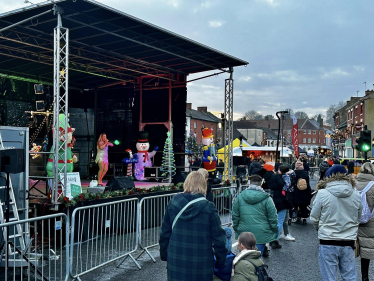 View of the Ashby-de-la-Zouch Christmas Market with performers, shops and members of the public.
